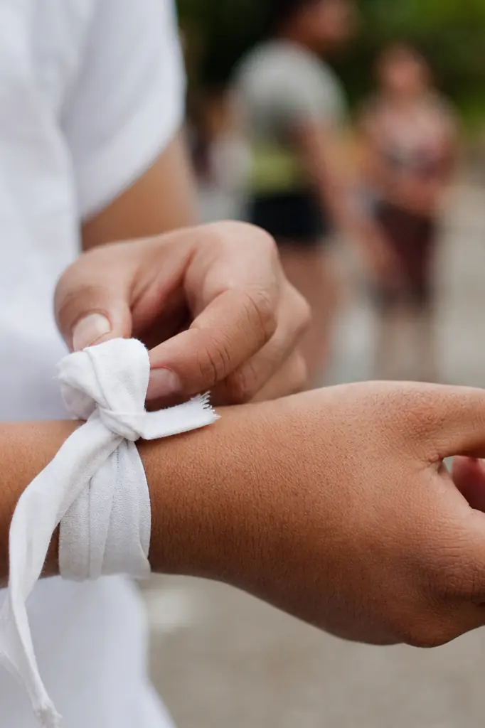 Personne attachant un bandeau blanc autour du poignet, symbole de solidarité